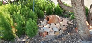 a garden with a pile of rocks and a tree at Sarakiniko Rooms in Adamantas