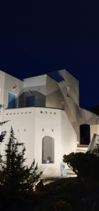 a white building with two chairs in front of it at Sarakiniko Rooms in Adamantas