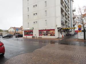 um edifício numa rua chuvosa com uma loja em Apartment Oulu station suite em Oulu