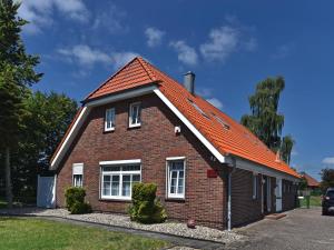 ein rotes Backsteinhaus mit orangefarbenem Dach in der Unterkunft Residenz 11 in Bad Zwischenahn