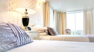 a bedroom with two beds and a lamp and a window at Bessiestown Country Guesthouse in Carlisle