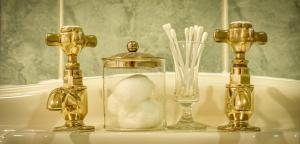 un groupe de trois bouteilles et un bocal en verre avec des brosses à dents dans l'établissement Bessiestown Country Guesthouse, à Carlisle