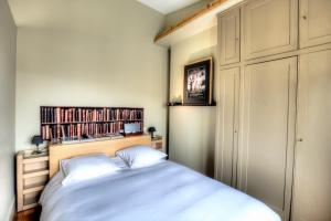 1 dormitorio con cama y estante para libros en Atelier dernier étage bail mobilité Louvre, en París