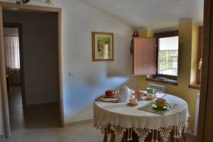 a table in a kitchen with a white table cloth on it at B&B Il Girasole in Camigliatello Silano