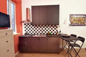 una cucina con lavandino e tavolo con sedie di Cluverio Centro Città Corallo a Palermo