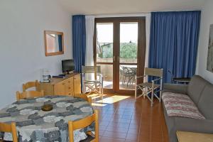 ein Wohnzimmer mit einem Sofa und einem Tisch sowie ein Zimmer mit einem Fenster in der Unterkunft Villaggio Barbara in Moniga