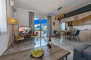 a living room with a couch and a table with a bottle of wine at Platanias Villa Spyros in Platanes