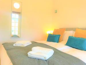 ein Schlafzimmer mit 2 Betten und Handtüchern darauf in der Unterkunft Seaside Cottage with Parking in Worthing