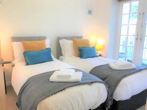 ein Schlafzimmer mit 2 Betten und Handtüchern darauf in der Unterkunft Seaside Cottage with Parking in Worthing