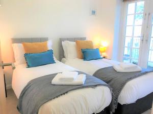 ein Schlafzimmer mit zwei Betten mit Handtüchern darauf in der Unterkunft Seaside Cottage with Parking in Worthing