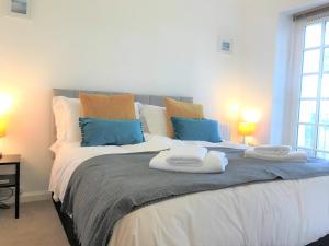a bedroom with a large bed with towels on it at Seaside Cottage with Parking in Worthing