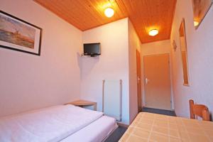 Habitación con cama, mesa y TV. en Gasthof zur Krone, en Burghaslach
