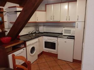 eine Küche mit weißen Schränken, einer Spüle und einem Geschirrspüler in der Unterkunft Casa Graciano II in Ochagavía