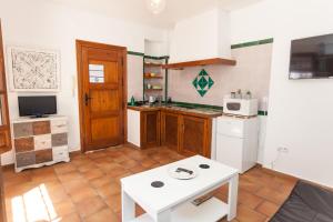 a kitchen with a table and a white refrigerator at Casa Larga in Granada