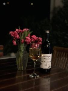 una bottiglia di vino e un vaso di fiori su un tavolo di Villa Vlajina a Primošten