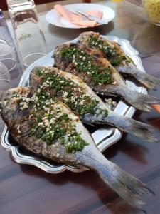 tre pesci su un piatto su un tavolo di Villa Vlajina a Primošten