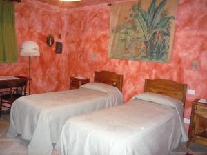two beds in a room with red walls at L'Adele Bed & Breakfast in Occimiano
