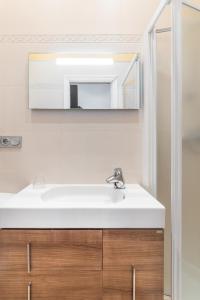 a bathroom with a white sink and a mirror at San Martin 2 - Local Rentss in San Sebastián