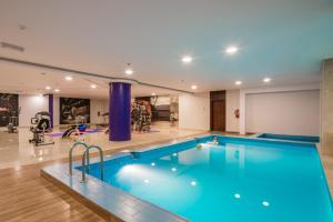 a large swimming pool in a large room with a gym at Le Park Concord Hotel in Arar