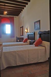 a bedroom with two beds with red pillows at Casa Maika in Montoro