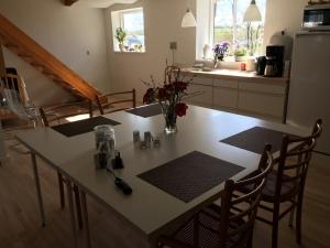 a kitchen with a table and some chairs and a counter at Lundgaarde Bed & Breakfast in Kjellerup