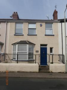 a house with a blue door and a fence at Riverside House in Bideford