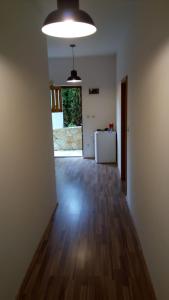 an empty room with a hard wood floor and a refrigerator at hostel Stalno Sretan in Labin