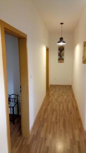 een lege kamer met een hal met een houten vloer bij hostel Stalno Sretan in Labin