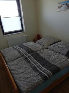 Bett in einem Schlafzimmer mit Fenster in der Unterkunft Ferienhaus Edeltraud in Dargen