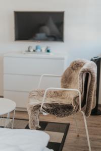 a chair in a living room with a tv at Residenz Fischbach KIBA in Friedrichshafen