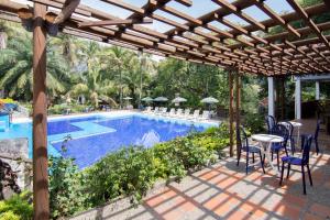 un patio con mesa y sillas junto a una piscina en Hotel el Tesoro, en San Jerónimo
