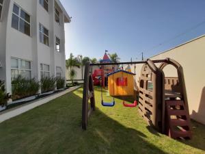 a playground in a yard next to a building at Colônia de Férias Sindi Fast in Peruíbe
