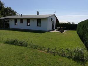 une petite maison blanche avec une cour herbeuse dans l'établissement Ferienhaus Edeltraud, à Dargen