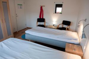 a room with two beds and a desk and two chairs at STF Valbergsängen Sporthotell in Torsby