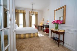 um quarto de hotel com uma cama e um espelho em Alvear Palace Hotel - Leading Hotels of the World em Buenos Aires