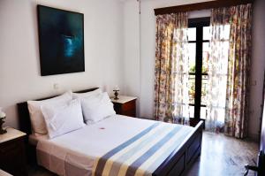 - une chambre avec un lit et une grande fenêtre dans l'établissement Villa Petra, à Kalamaki Messinia