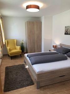 a bedroom with a bed and a yellow chair at Haus Fuetsch in Virgen