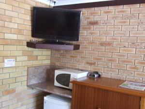 A television and/or entertainment centre at Pacific Paradise Airport Motel