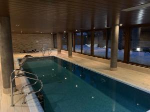 a large swimming pool in a building with a pool at El Estacho de Panticosa in Panticosa