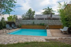 een zwembad met 2 stoelen en een hek bij Casita en La Sierra in Zarzalejo