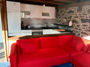 um sofá vermelho num quarto com uma cozinha em Historische Ferienwohnung mit Sauna in Lich em Lich