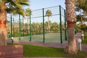 a tennis court in a park with palm trees at Apartamento Playa y Golf con PARKING INCLUIDO in Motril