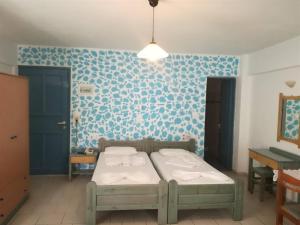 1 dormitorio con cama y pared azul en Olympic Star, en Hersonissos