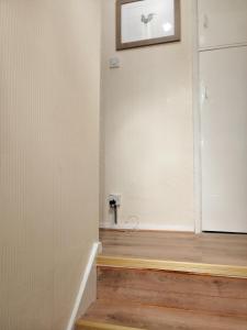 een kamer met een witte muur en een houten vloer bij Memory Homes MM H in Manchester +27 foto's