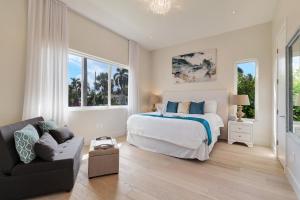 um quarto branco com uma cama e um sofá em Modern Luxurious Beach Retreat-5 Br with/pool em Hollywood