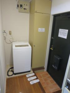 Zimmer mit einer Tür und einem kleinen Kühlschrank in der Unterkunft Stay Snnabe / Vacation STAY 52638 in Kumamoto