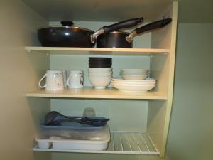 ein Regal mit Geschirr und Küchenutensilien in einer Küche in der Unterkunft Stay Snnabe / Vacation STAY 52638 in Kumamoto