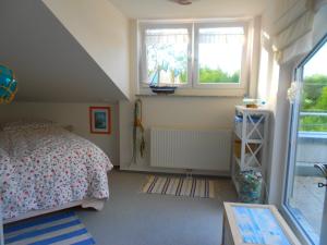 a bedroom with a bed and two windows at Ferienwohnung Meeresrauschen in Graal-Müritz