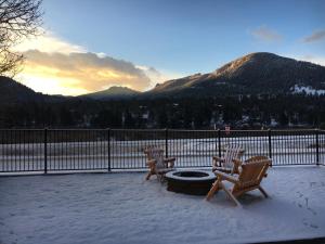 un groupe de chaises assises autour d'un foyer extérieur dans la neige dans l'établissement Alpine Trail Ridge Inn, à Estes Park