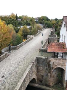 a stone bridge over a river with a road at Ferienwohnung Bartenwetzerbrücke in Melsungen